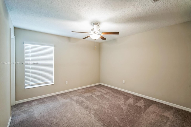 carpeted empty room with a textured ceiling, baseboards, and ceiling fan