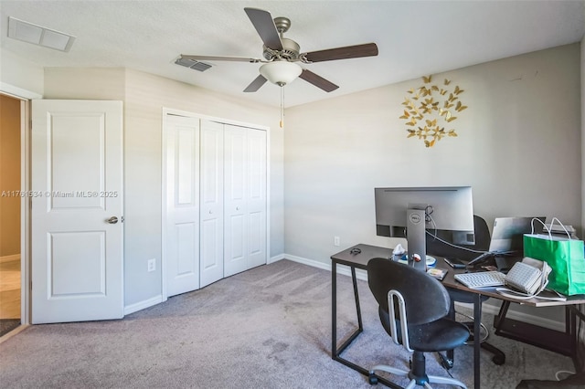 carpeted home office featuring visible vents, baseboards, and a ceiling fan