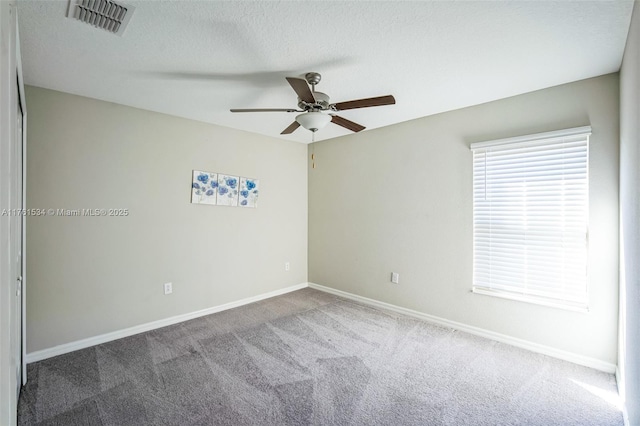 unfurnished room with visible vents, baseboards, a textured ceiling, and carpet flooring