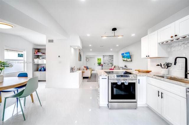 kitchen featuring visible vents, open floor plan, stainless steel electric stove, a peninsula, and a sink