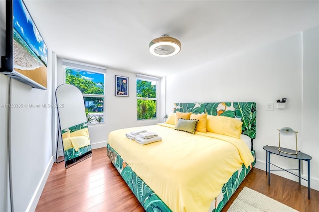 bedroom with wood finished floors and baseboards