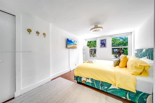 bedroom featuring wood finished floors and baseboards