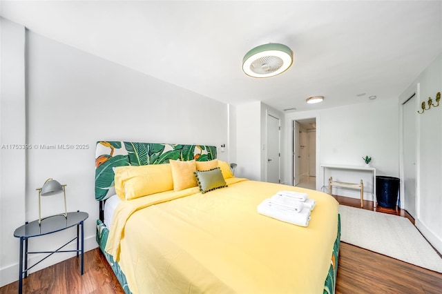 bedroom with a closet, baseboards, and wood finished floors