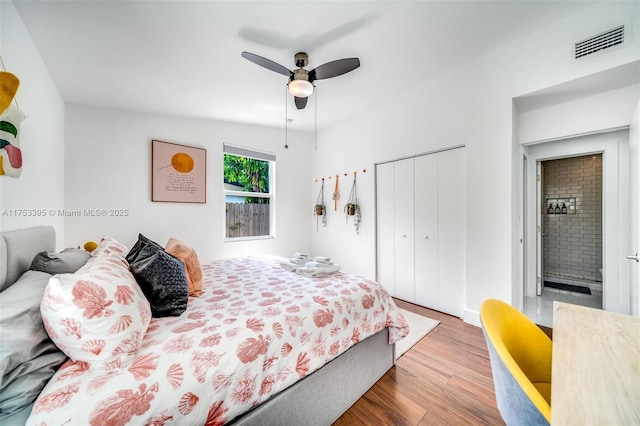 bedroom featuring ceiling fan, visible vents, a closet, and wood finished floors