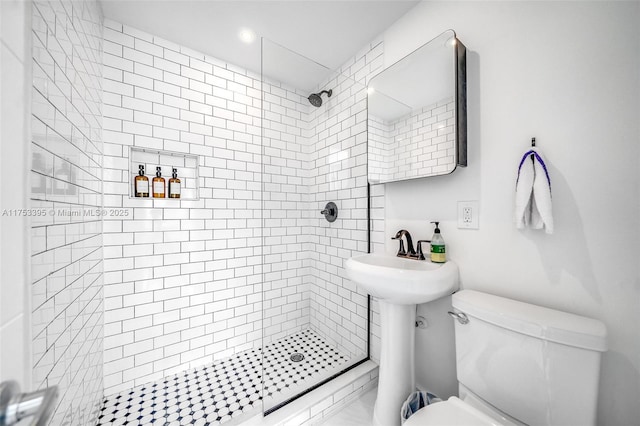 bathroom featuring tiled shower and toilet