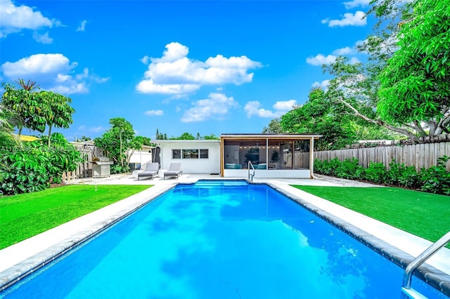 back of property featuring a yard, a fenced backyard, a fenced in pool, and a sunroom