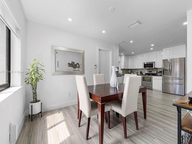 dining room with recessed lighting, visible vents, light wood finished floors, and baseboards