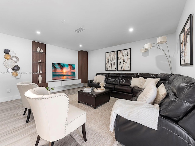 living area featuring baseboards, recessed lighting, visible vents, and light wood-type flooring