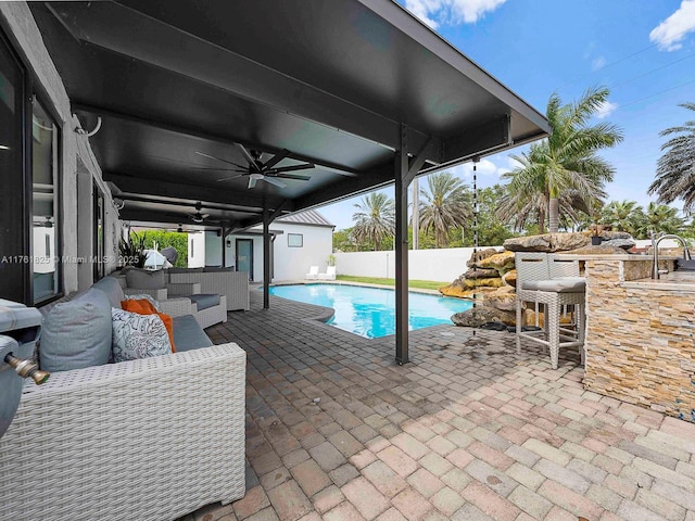 view of pool featuring outdoor dry bar, a fenced in pool, a patio, and ceiling fan