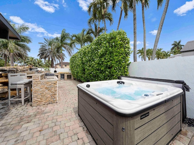 view of patio / terrace featuring outdoor dry bar and a hot tub