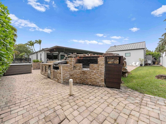 view of patio / terrace featuring an outdoor kitchen, a jacuzzi, and a grill