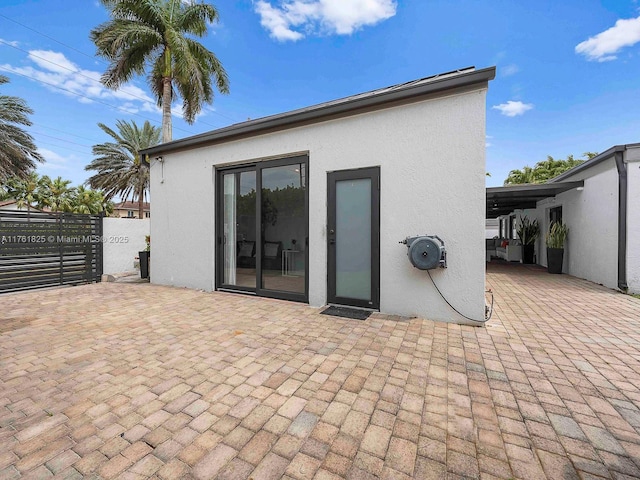 back of house featuring stucco siding and fence