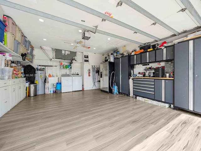 garage with a ceiling fan, water heater, stainless steel refrigerator with ice dispenser, washer and dryer, and a garage door opener