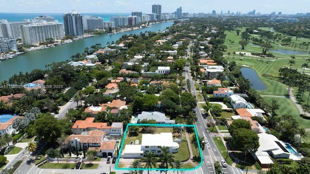drone / aerial view with a water view, golf course view, and a view of city