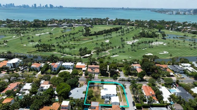 drone / aerial view featuring a water view, golf course view, and a view of city