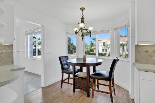 dining area featuring a chandelier, light wood-style floors, and a healthy amount of sunlight