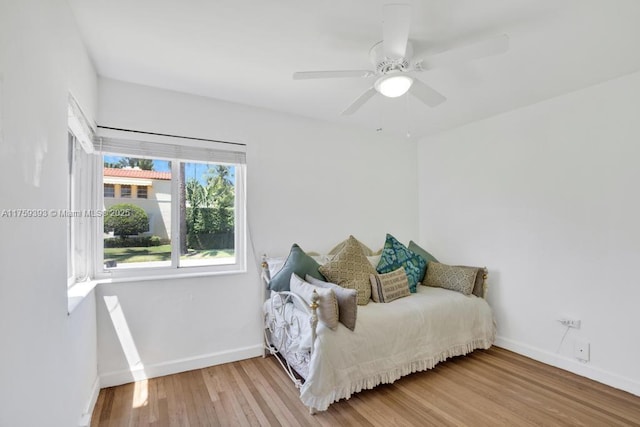 bedroom with baseboards, ceiling fan, and wood finished floors