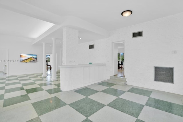 unfurnished room featuring visible vents, ornate columns, and a healthy amount of sunlight