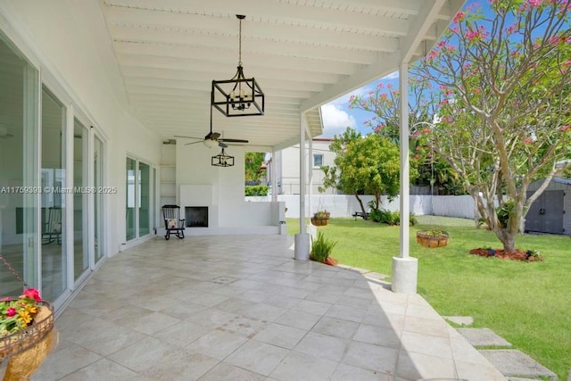 view of patio / terrace with an outbuilding, ceiling fan, fence, and a shed