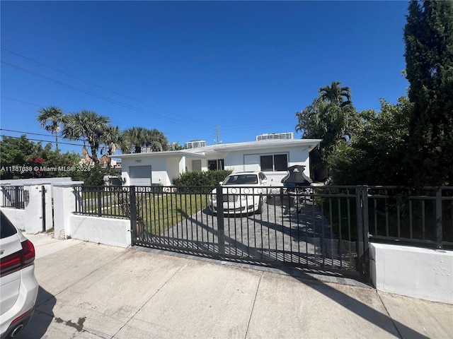 view of front of house with a gate, a fenced front yard, and stucco siding