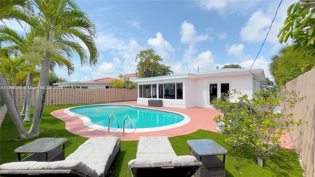 view of swimming pool with a patio, a fenced backyard, a fenced in pool, and a sunroom