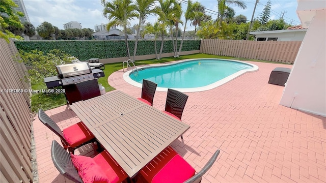 view of swimming pool featuring outdoor dining area, a fenced backyard, and a patio area