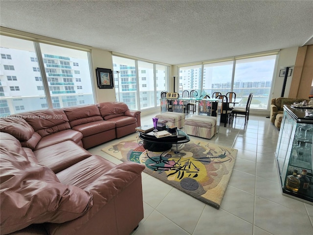 living area with tile patterned flooring, floor to ceiling windows, a view of city, and a textured ceiling