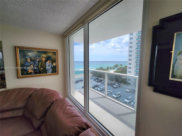 living room featuring a textured ceiling and a water view