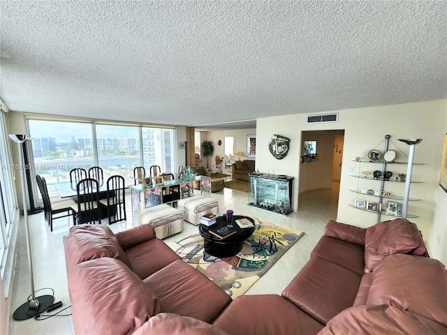 tiled living room featuring visible vents and a textured ceiling