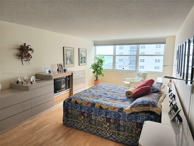 bedroom with wood finished floors and a textured ceiling