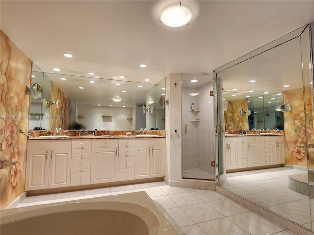 bathroom with tile patterned floors, a stall shower, and a sink