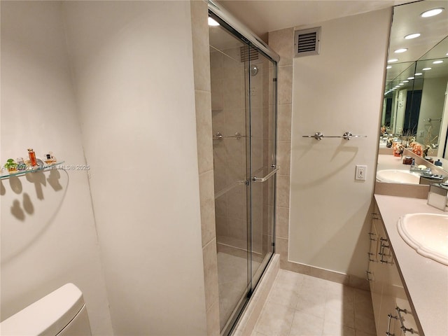 bathroom featuring visible vents, a stall shower, toilet, and a sink