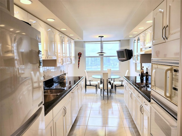 hall featuring light tile patterned floors and baseboards