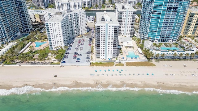 birds eye view of property with a view of city, a water view, and a beach view