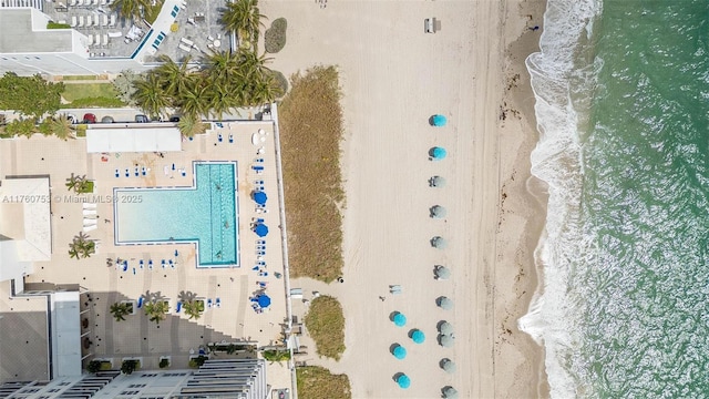 bird's eye view featuring a water view and a beach view