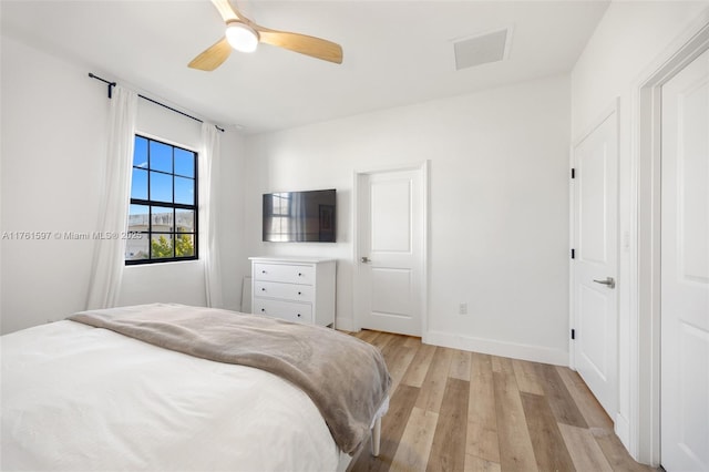 bedroom with visible vents, baseboards, light wood finished floors, and ceiling fan