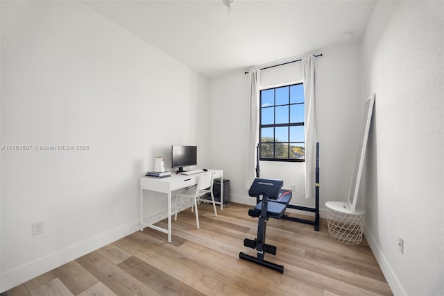 office area featuring baseboards and light wood finished floors