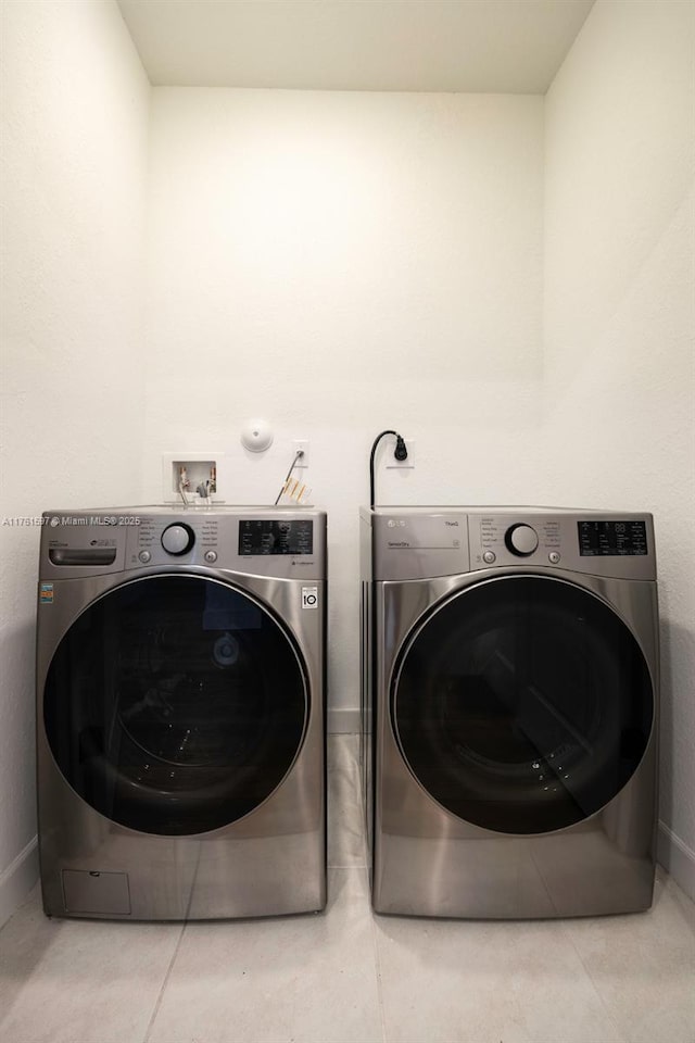 laundry area featuring tile patterned floors, laundry area, and washing machine and clothes dryer