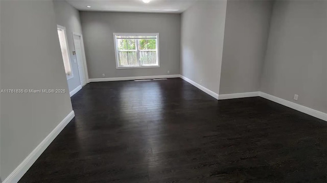 unfurnished room featuring dark wood-style floors and baseboards