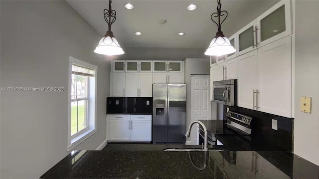 kitchen with a sink, stainless steel appliances, glass insert cabinets, and white cabinetry