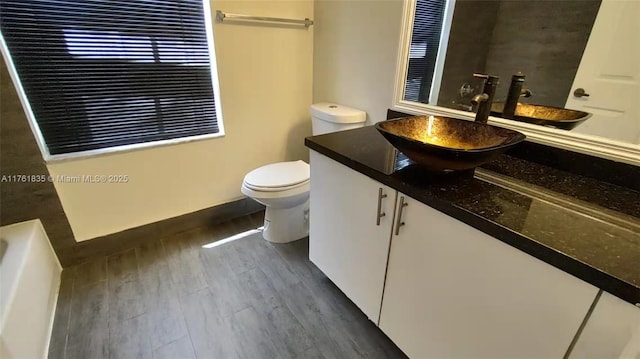 full bath featuring toilet, vanity, and wood finished floors