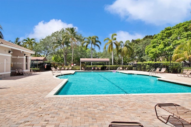 community pool featuring a patio and fence