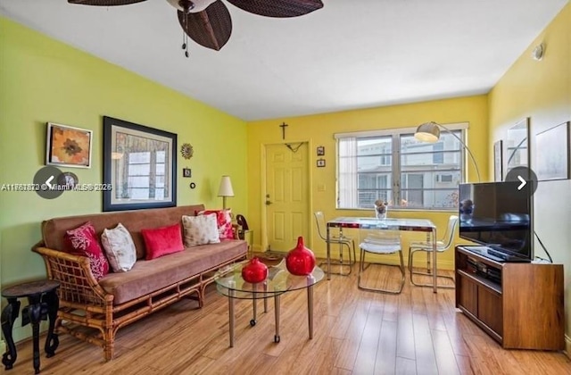 living area with a ceiling fan and wood finished floors