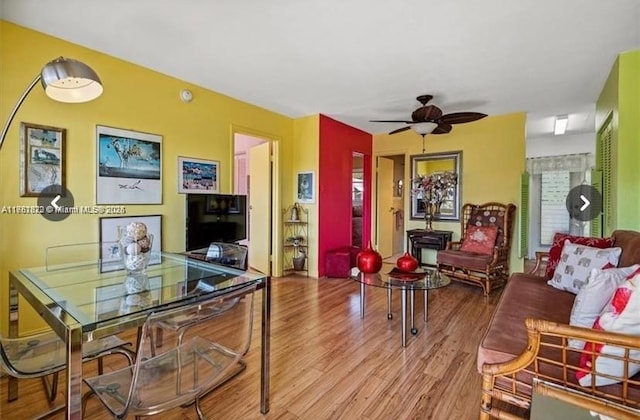 living area with a ceiling fan and wood finished floors