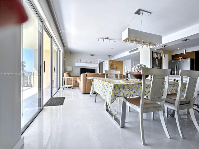 dining area featuring light tile patterned floors and a fireplace