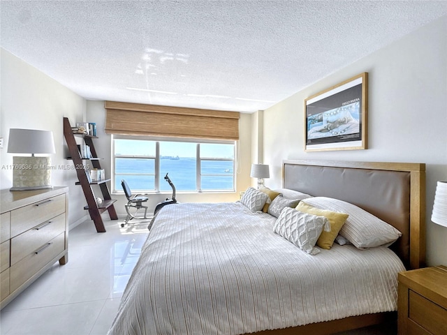 bedroom with light tile patterned floors and a textured ceiling