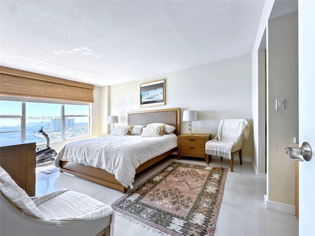 tiled bedroom featuring baseboards and a textured ceiling