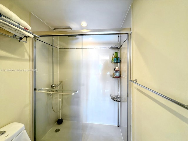 bathroom featuring toilet and a shower stall