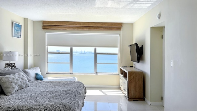 bedroom featuring light tile patterned floors and a textured ceiling