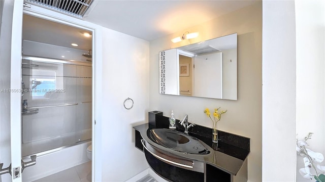 bathroom featuring visible vents, toilet, tile patterned floors, combined bath / shower with glass door, and vanity